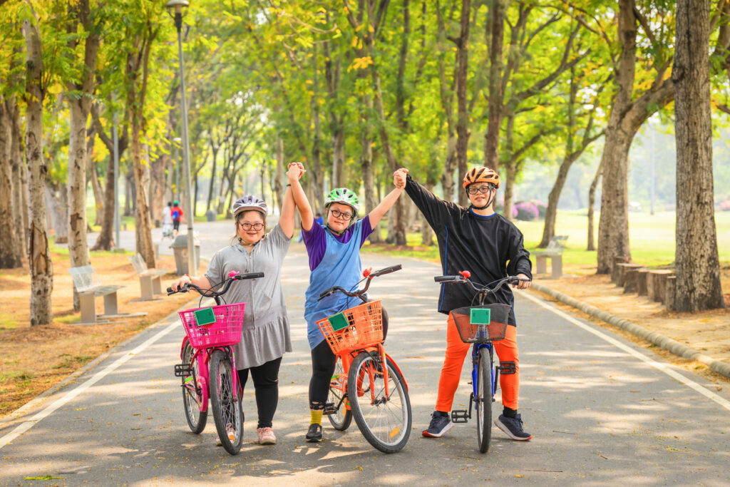 Global events for Autism Awareness Month: Group of friends with autism riding a bicycle in a park.